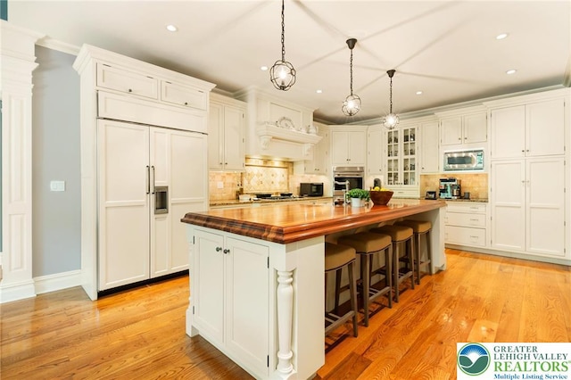 2051 Forge Run, Bethlehem City, PA 18015 - kitchen featuring butcher block counters, built in appliances, an island with sink, white cabinets, and recessed lighting