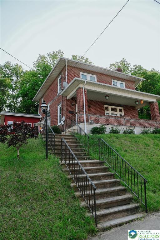 5242 3rd St, Whitehall Twp, PA 18052 - view of front of property featuring brick siding, a front lawn, and stairway