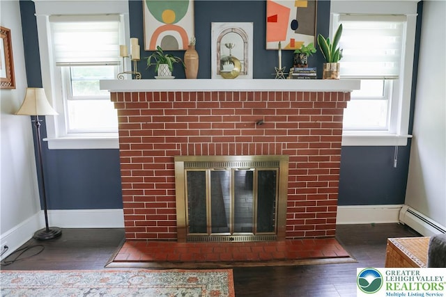 5242 3rd St, Whitehall Twp, PA 18052 - detailed view of a fireplace, a baseboard heating unit, and wood finished floors