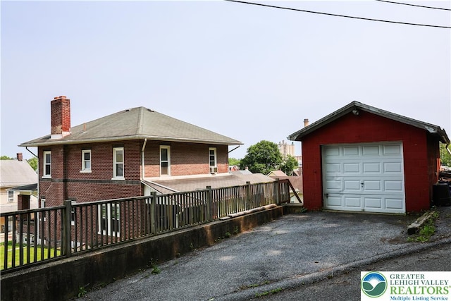 5242 3rd St, Whitehall Twp, PA 18052 - view of home's exterior featuring a garage, a chimney, driveway, and an outdoor structure