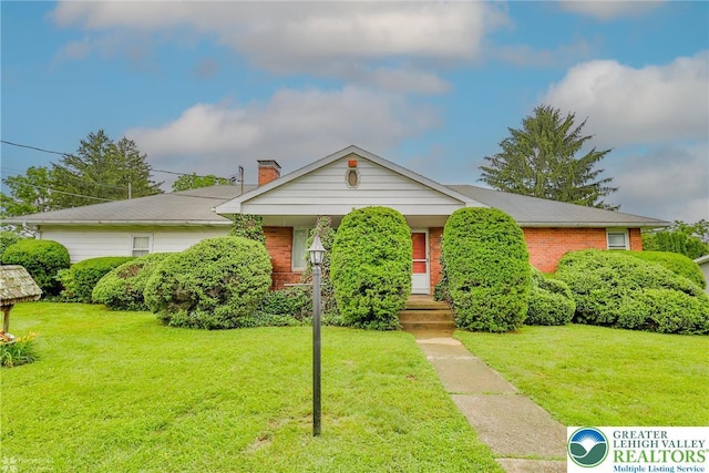 3609 Erie St, Palmer Twp, PA 18045 - view of front of house featuring brick siding, a front lawn, and a chimney