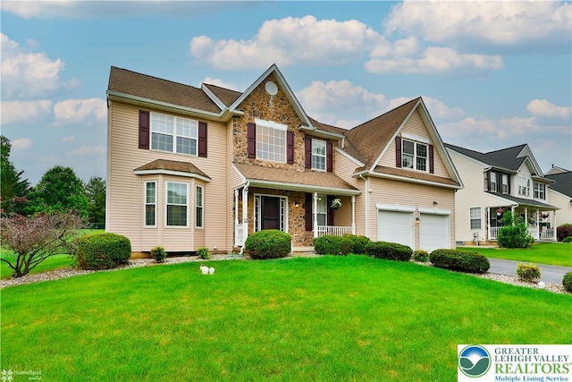 10 Windrift Ct, Easton, PA 18045 - view of front of property with stone siding, covered porch, an attached garage, and a front lawn