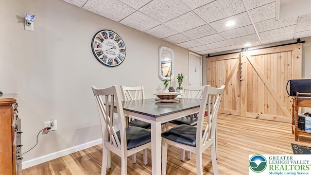 3954 Cedar Dr, Lehigh Twp, PA 18088 - dining room featuring a barn door, light wood-type flooring, and a drop ceiling