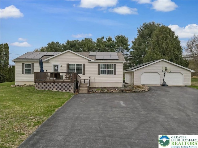 3954 Cedar Dr, Lehigh Twp, PA 18088 - view of front of home featuring a detached garage, an outdoor structure, a front yard, a wooden deck, and roof mounted solar panels