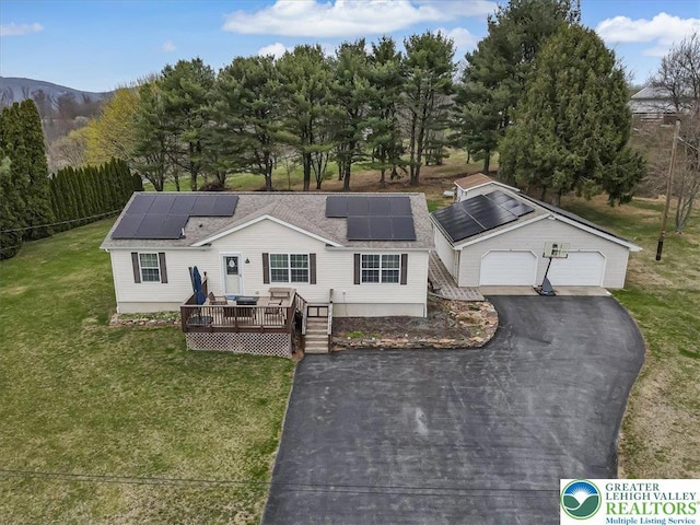 3954 Cedar Dr, Lehigh Twp, PA 18088 - view of front of house with a deck with mountain view, a front yard, a detached garage, solar panels, and roof with shingles