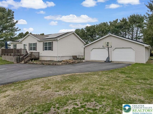 3954 Cedar Dr, Lehigh Twp, PA 18088 - view of front facade with a deck, roof mounted solar panels, a detached garage, and a front yard