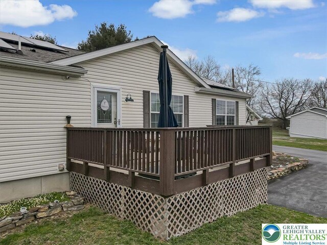 3954 Cedar Dr, Lehigh Twp, PA 18088 - rear view of property with a deck, a shingled roof, and solar panels
