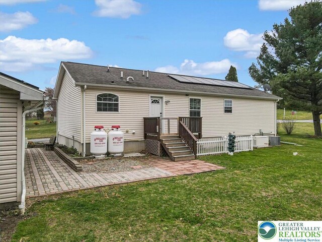 3954 Cedar Dr, Lehigh Twp, PA 18088 - rear view of property featuring a lawn, roof mounted solar panels, and a patio