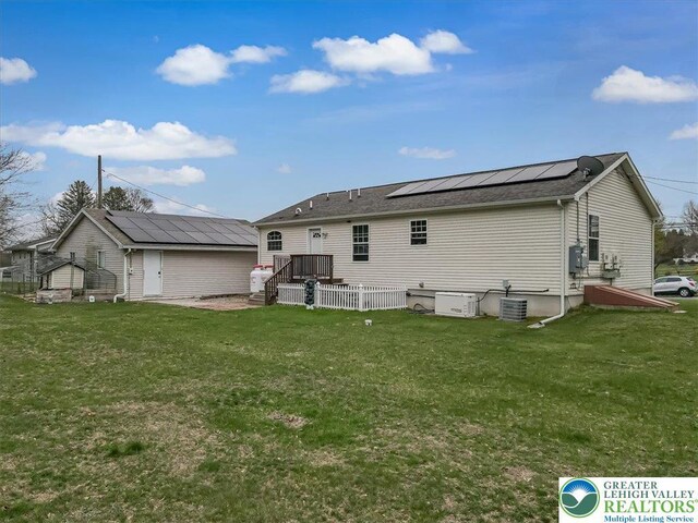 3954 Cedar Dr, Lehigh Twp, PA 18088 - back of house with roof mounted solar panels, a lawn, and a wooden deck