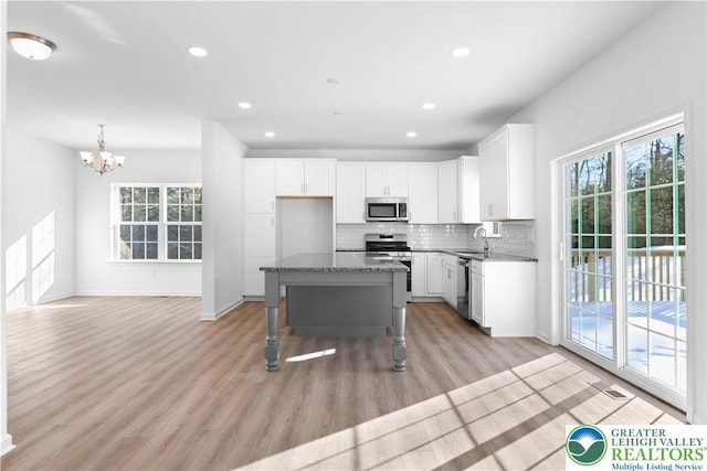 718 Rte 314 Unit 2, Pocono Twp, PA 18370 - kitchen with stainless steel appliances, backsplash, white cabinets, a chandelier, and light wood finished floors