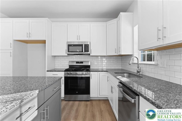 718 Rte 314 Unit 2, Pocono Twp, PA 18370 - kitchen featuring stainless steel appliances, light wood-style flooring, dark stone counters, and white cabinetry