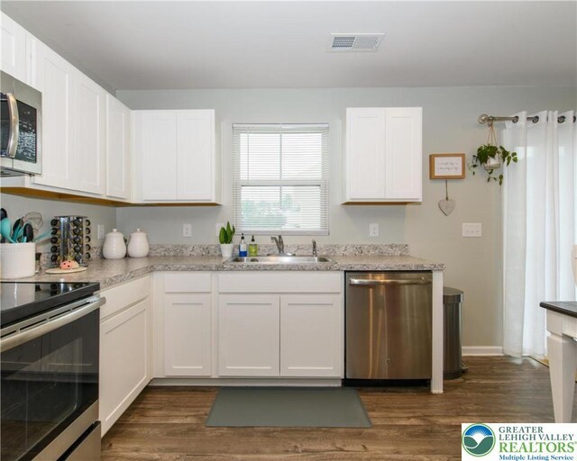 403 Lock Dr, Allen Twp, PA 18067 - kitchen featuring appliances with stainless steel finishes, dark wood finished floors, and white cabinetry