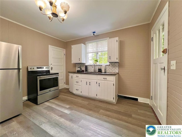 737 Frost Hollow Rd, Easton, PA 18040 - kitchen with stainless steel appliances, dark countertops, a chandelier, light wood-style floors, and crown molding
