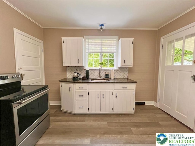 737 Frost Hollow Rd, Easton, PA 18040 - kitchen featuring stainless steel electric range oven, dark countertops, healthy amount of natural light, white cabinetry, and ornamental molding