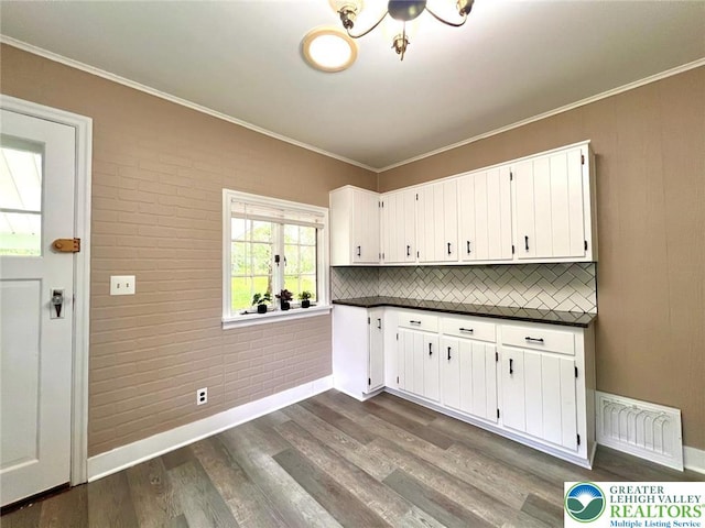 737 Frost Hollow Rd, Easton, PA 18040 - kitchen featuring dark countertops, dark wood-style flooring, white cabinets, decorative backsplash, and ornamental molding