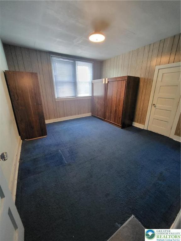 419 E Walnut St, Allentown City, PA 18109 - unfurnished bedroom featuring wooden walls and dark carpet