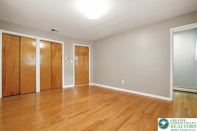 627 Columbia Ave, Palmerton Boro, PA 18071 - unfurnished bedroom with light wood finished floors, a baseboard radiator, and multiple closets