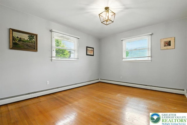 627 Columbia Ave, Palmerton Boro, PA 18071 - empty room featuring healthy amount of natural light, light wood-style floors, a baseboard heating unit, and a chandelier