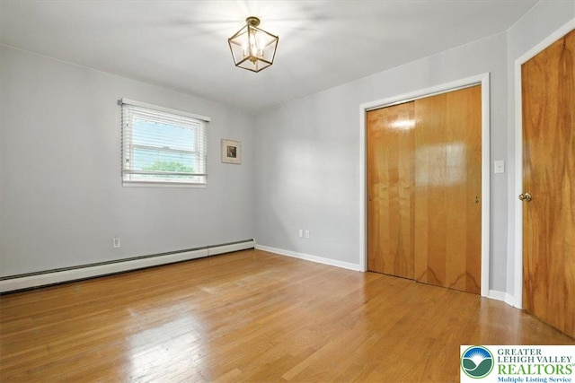627 Columbia Ave, Palmerton Boro, PA 18071 - unfurnished bedroom featuring a baseboard radiator, wood finished floors, and a chandelier