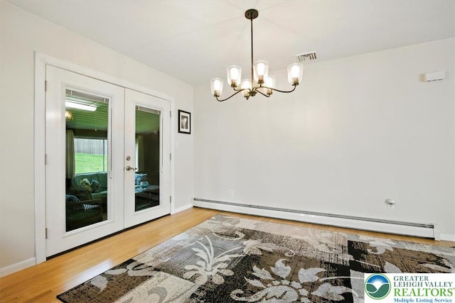 627 Columbia Ave, Palmerton Boro, PA 18071 - dining space featuring a baseboard heating unit, french doors, wood finished floors, and a chandelier