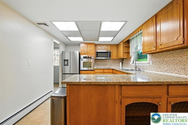 627 Columbia Ave, Palmerton Boro, PA 18071 - kitchen featuring stainless steel appliances, baseboard heating, a peninsula, brown cabinetry, and decorative backsplash