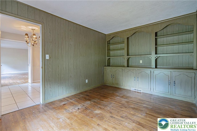 1265 Clearview Cir, Lower Macungie Twp, PA 18103 - spare room featuring a chandelier, wood walls, wood finished floors, and built in features
