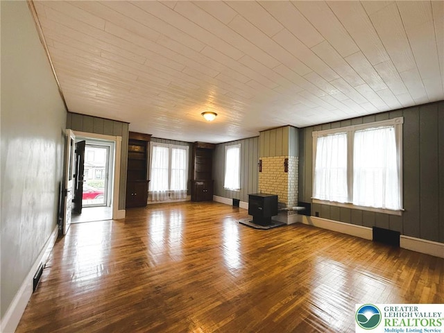 233 Lafayette Ave, Palmerton Boro, PA 18071 - unfurnished living room with wooden ceiling, wooden walls, wood finished floors, and a wood stove