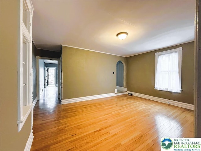 233 Lafayette Ave, Palmerton Boro, PA 18071 - empty room with light wood-style flooring, plenty of natural light, arched walkways, and ornamental molding