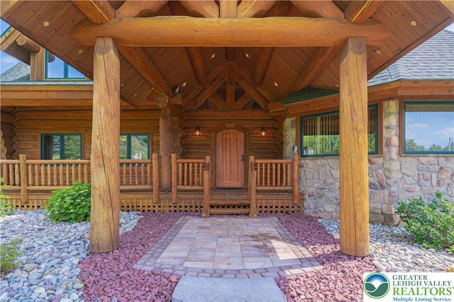 379 Meyer Rd, Bushkill Twp, PA 18064 - entrance to property featuring stone siding, log siding, roof with shingles, and a porch