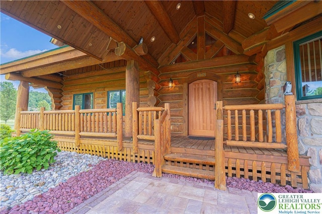 379 Meyer Rd, Bushkill Twp, PA 18064 - view of exterior entry featuring stone siding, log exterior, and a porch