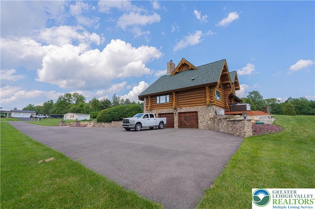 379 Meyer Rd, Bushkill Twp, PA 18064 - view of property exterior featuring log exterior, a chimney, a garage, a yard, and stone siding