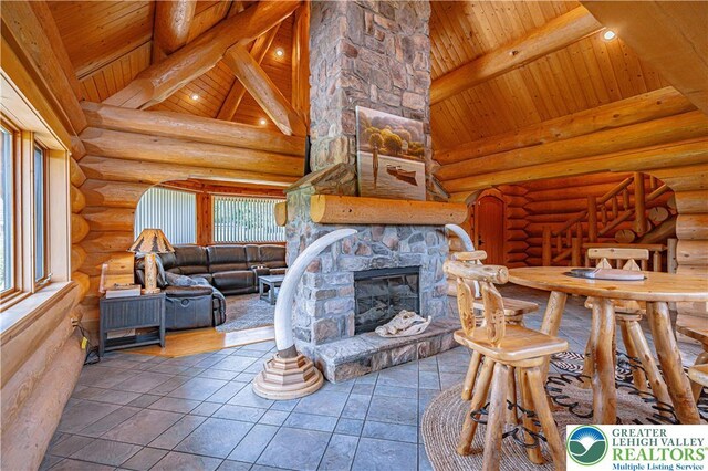 379 Meyer Rd, Bushkill Twp, PA 18064 - living area with a wooden ceiling with exposed beams, healthy amount of natural light, log walls, high vaulted ceiling, and a stone fireplace