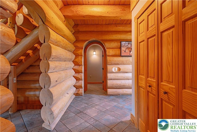 379 Meyer Rd, Bushkill Twp, PA 18064 - hallway featuring log walls, arched walkways, and a wood ceiling with exposed beams