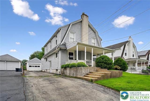 815 Summit Ave, Prospect Park, PA 19076 - dutch colonial featuring covered porch, a detached garage, a gambrel roof, a chimney, and an outbuilding