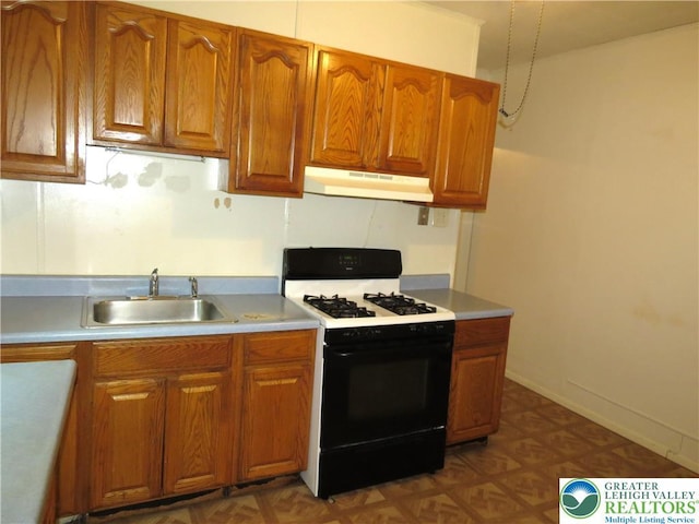 2206 Forest St, Wilson Boro, PA 18042 - kitchen with gas stove, under cabinet range hood, brown cabinetry, and light countertops