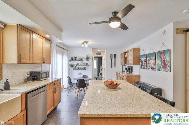 1925 Peach Tree Ln, Lower Saucon Twp, PA 18015 - kitchen featuring stainless steel appliances, ceiling fan, decorative backsplash, light stone counters, and a kitchen island