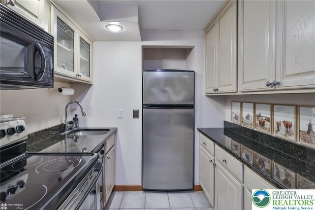 1925 Peach Tree Ln, Lower Saucon Twp, PA 18015 - kitchen featuring appliances with stainless steel finishes, glass insert cabinets, light tile patterned floors, and dark stone counters