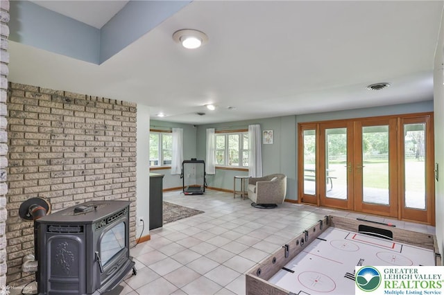 1925 Peach Tree Ln, Lower Saucon Twp, PA 18015 - playroom featuring a wood stove, light tile patterned floors, and french doors