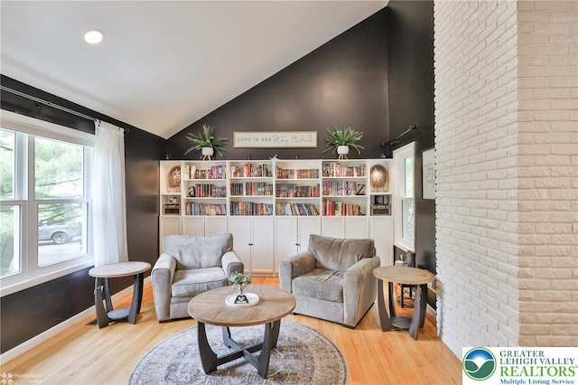 1925 Peach Tree Ln, Lower Saucon Twp, PA 18015 - living area featuring wood finished floors, healthy amount of natural light, brick wall, and high vaulted ceiling