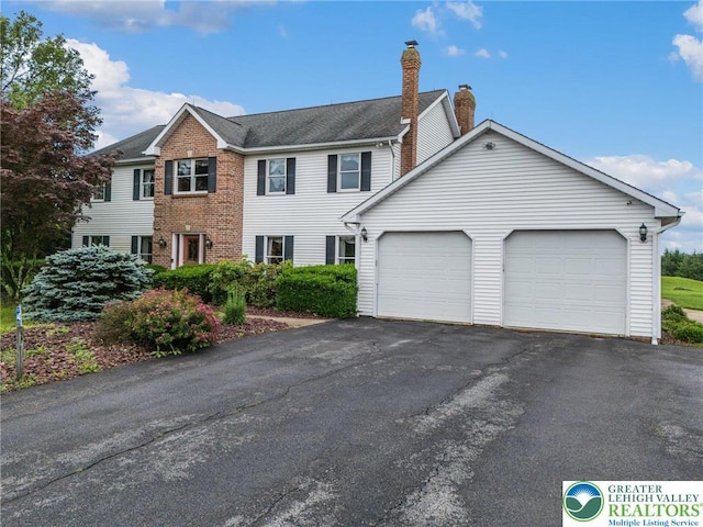 1151 Marfield Dr, Bushkill Twp, PA 18064 - view of front facade with a garage, a chimney, and asphalt driveway