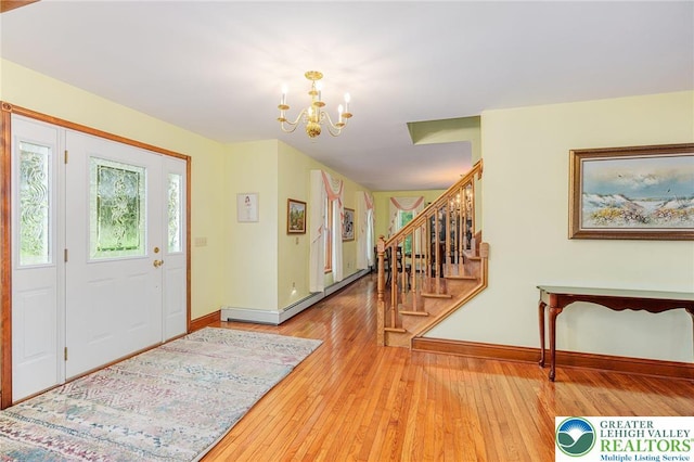 1151 Marfield Dr, Bushkill Twp, PA 18064 - entrance foyer with a chandelier, stairs, hardwood / wood-style flooring, and baseboard heating