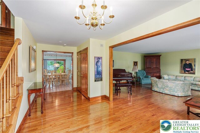 1151 Marfield Dr, Bushkill Twp, PA 18064 - living area featuring light wood-style floors, a chandelier, and stairs