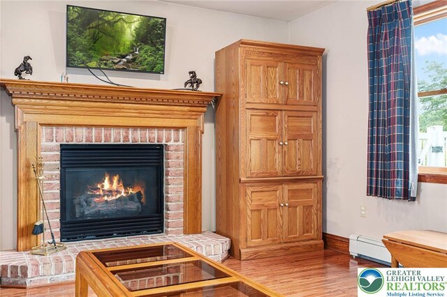 1151 Marfield Dr, Bushkill Twp, PA 18064 - detailed view of baseboard heating, wood finished floors, and a fireplace