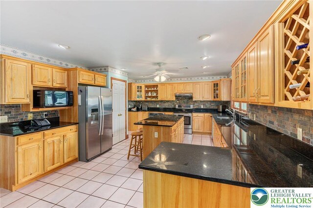 1151 Marfield Dr, Bushkill Twp, PA 18064 - kitchen featuring appliances with stainless steel finishes, light tile patterned floors, decorative backsplash, and under cabinet range hood
