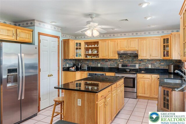 1151 Marfield Dr, Bushkill Twp, PA 18064 - kitchen featuring stainless steel appliances, light tile patterned flooring, under cabinet range hood, a kitchen island, and decorative backsplash