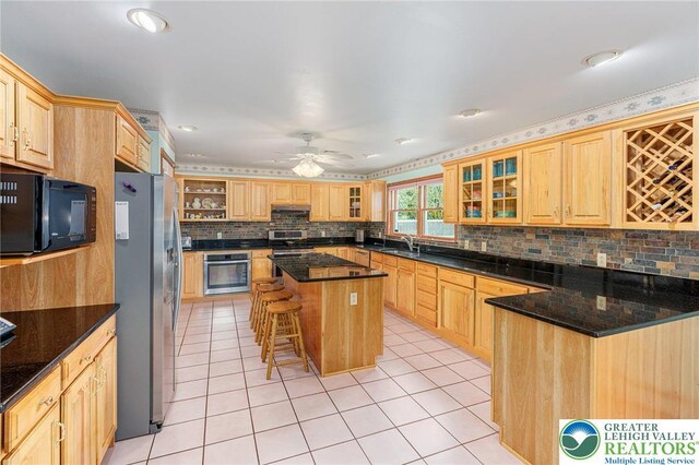1151 Marfield Dr, Bushkill Twp, PA 18064 - kitchen with stainless steel appliances, tasteful backsplash, light brown cabinets, glass insert cabinets, and light tile patterned floors