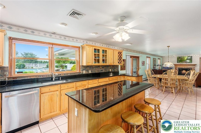 1151 Marfield Dr, Bushkill Twp, PA 18064 - kitchen with dishwasher, light tile patterned flooring, a breakfast bar, glass insert cabinets, and backsplash