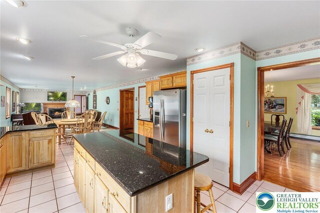 1151 Marfield Dr, Bushkill Twp, PA 18064 - kitchen featuring stainless steel fridge with ice dispenser, light tile patterned floors, a brick fireplace, a kitchen bar, and a ceiling fan
