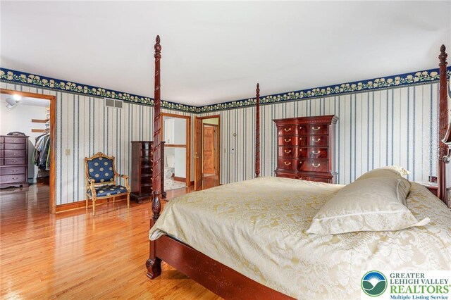 1151 Marfield Dr, Bushkill Twp, PA 18064 - bedroom featuring wallpapered walls, wood finished floors, and a spacious closet