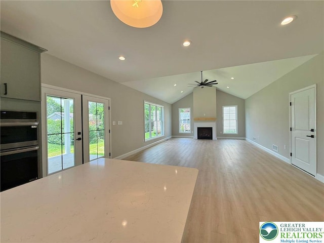 3631 Oak Ridge Dr, Washington Twp, PA 18080 - unfurnished living room with light wood-style flooring, lofted ceiling, a ceiling fan, recessed lighting, and a fireplace